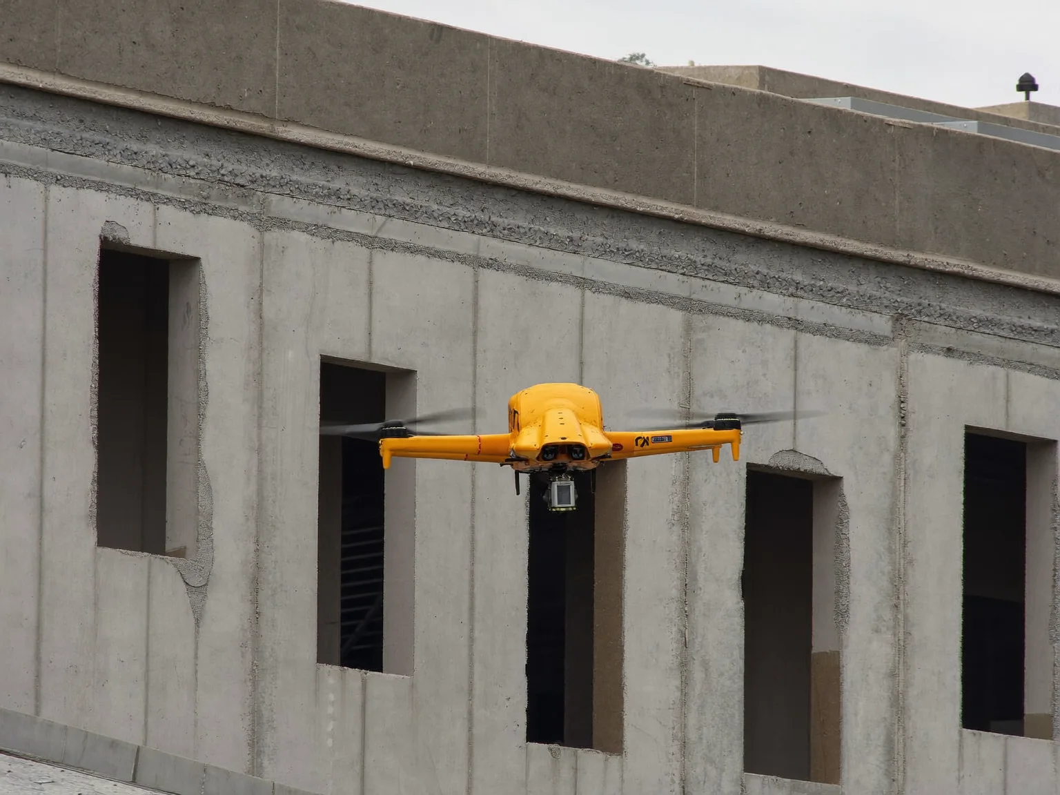 Inspection drone hovering close to a building facade under construction (AI-generated sample image)